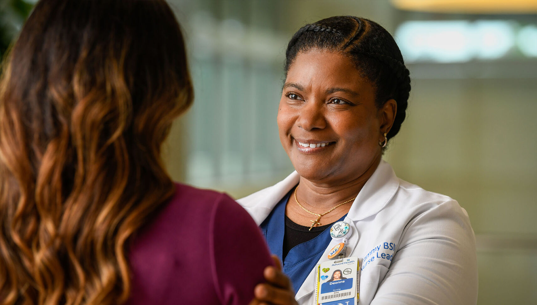 A nurse practitioner puts her hand on a person's shoulder