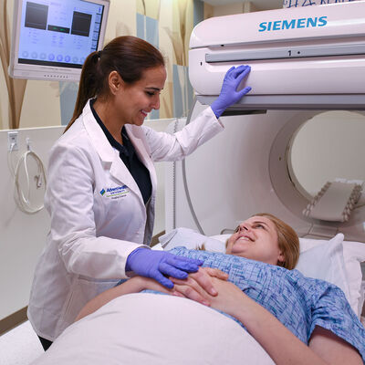 A female nuclear medicine student preparing to scan a patient