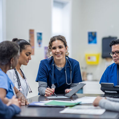 A female nurse supervisor meets with her team