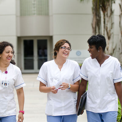 A group of female nursing students in uniform walking outside