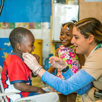 A female healthcare student providing care to a child on a mission trip